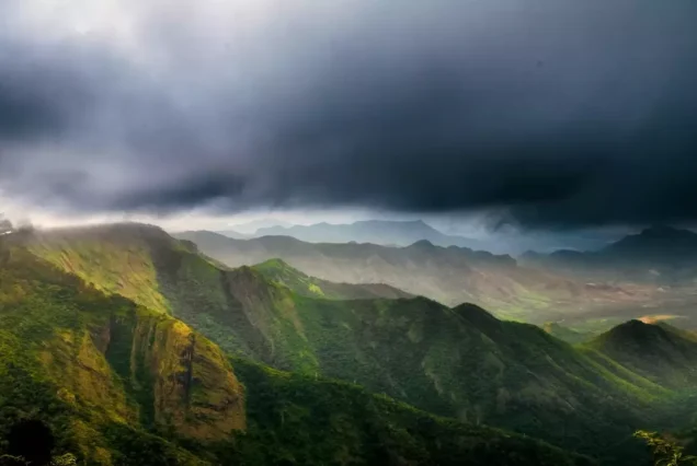 A breathtaking sunrise over Kodaikanal’s rolling hills, with trekkers enjoying the panoramic view.